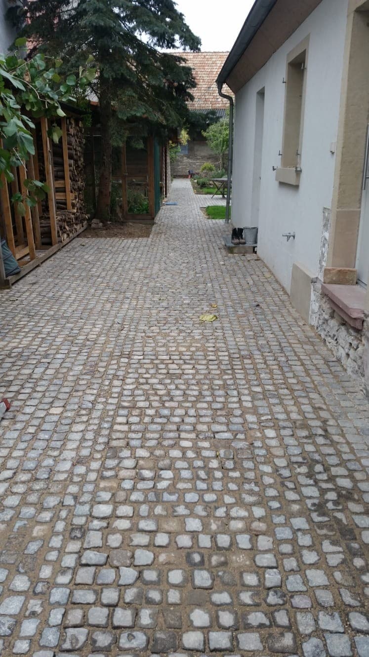 Mit Kopfsteinpflaster gestaltete Hofeinfahrt eines Wohnhauses